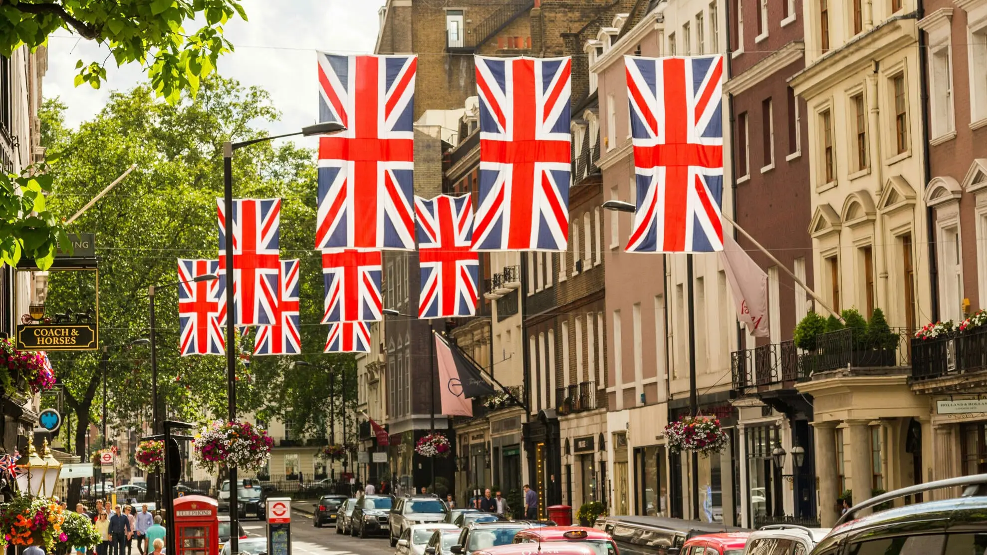 Straße mit Menschen und Union Jack-Flaggen