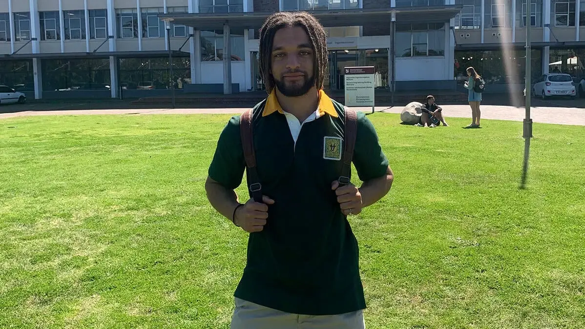 William in Südafrika Student William auf einer Wiese vor der Universität Stellenbosch in Südafrika