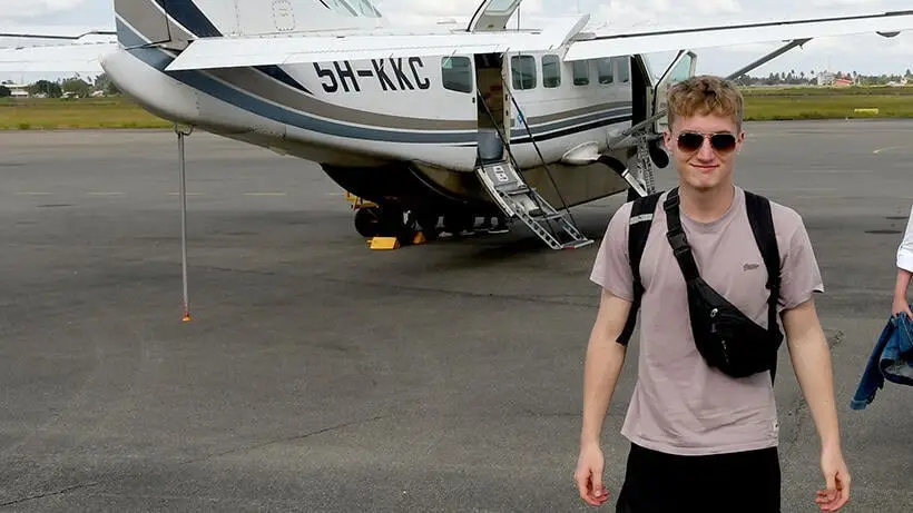 Andrija vor einem kleinen Passagierflugzeug auf dem Flughafen in Sansibar kurz vor dem Rückflug nach Dar es Salam