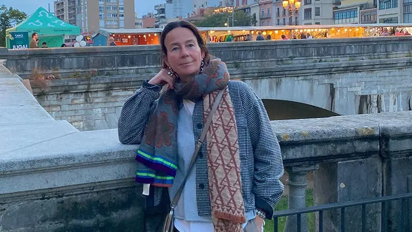 Manuela Winkler-Wolf steht vor einer Steinbrücke, im Hintergrund ist ein Markt zu sehen