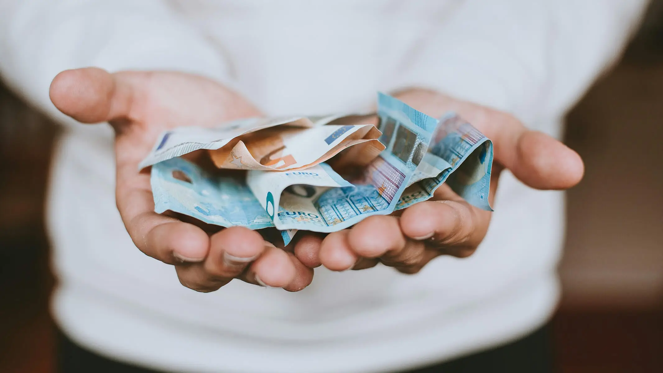 Mann hält mehrere Euro-Scheine in seinen Händen