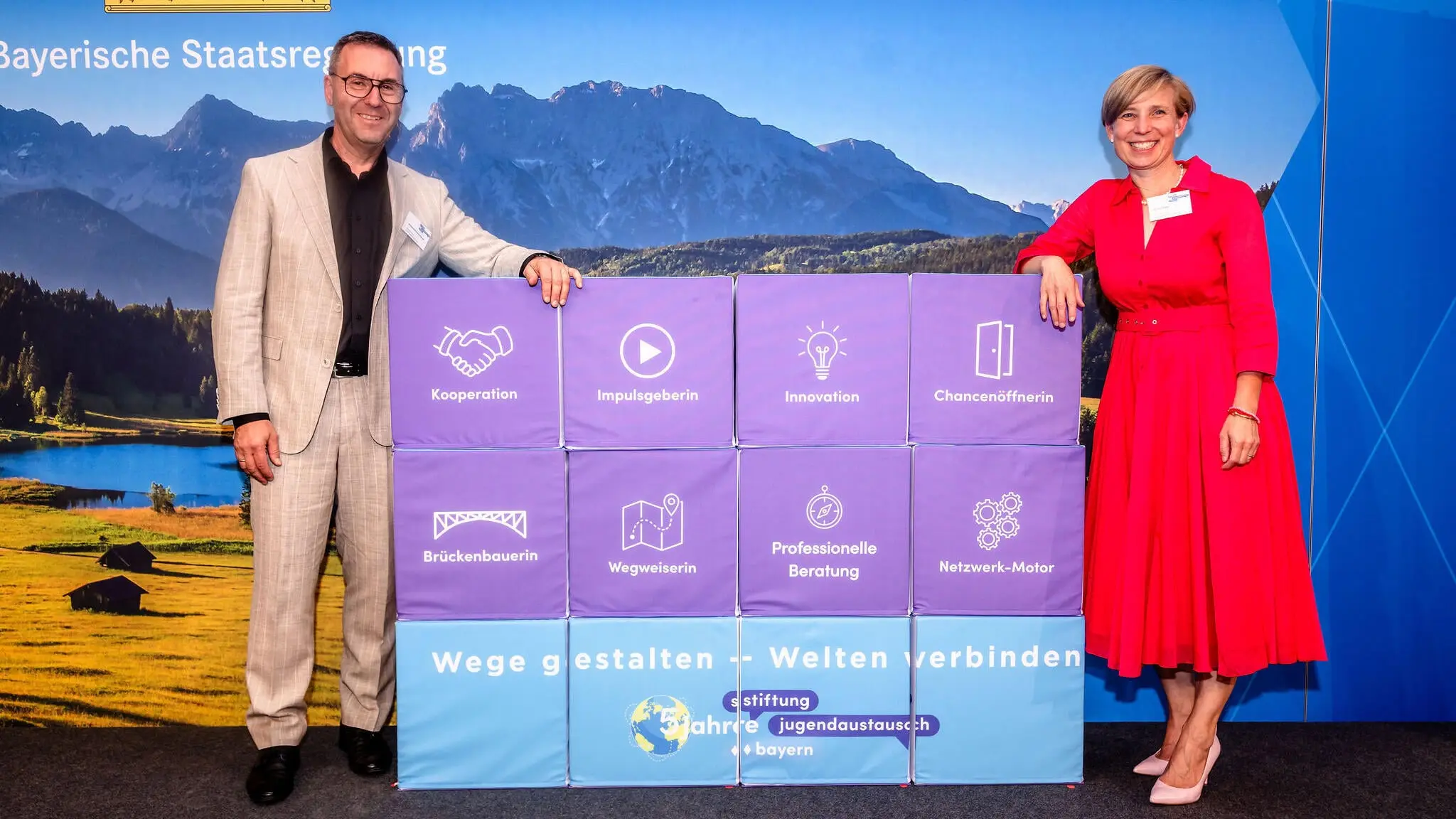 Geschäftführung Mirjam Eisele und Wolfgang Schwarzenberger beim Stiftungsjubiläum in München vor einer Würfelwand